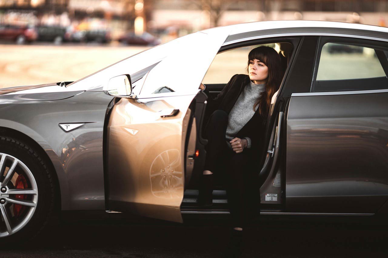 woman opening car door from inside driver's seat